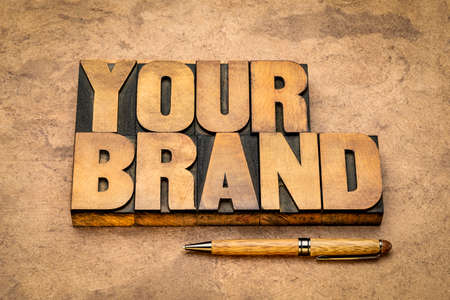 your brand word in vintage letterpress wood type against handmade textured paper, business marketing, trademark and identity conceptの写真素材