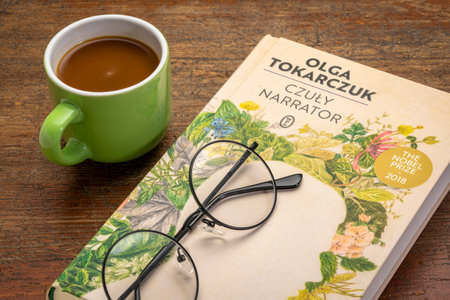 Fort Collins, CO, USA - March 20, 2021: The Tender Narrator (Polish edition), recent book by Olga Tokarczuk with coffee and reading glasses - 2018 Nobel Prize in literature.のeditorial素材