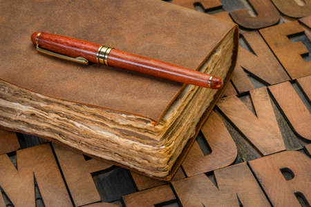 antique leatherbound journal with decked edge handmade paper pages and a stylish pen on a...