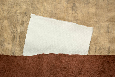 small sheet of blank white Khadi rag paper against earth tone abstract landscapeの写真素材