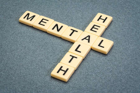 mental health crossword in ivory letter tiles against textured handmade paper, emotional, psychological and social well-beingの写真素材