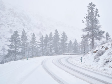 winter travel in Colorado Rocky Mountains - highway 14 in Poudre Canyon in a heavy early spring snowstormの写真素材