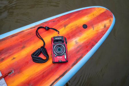 Fort Collins, CO, USA - May 9, 2021: Compact, waterproof Olympus Stylus Tough TG-5 camera on a rear deck of a stand up paddleboard by Mistral.のeditorial素材