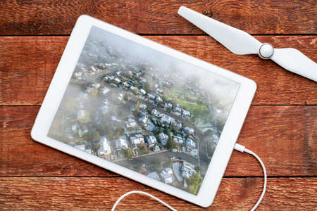 foggy spring morning over residential area of Fort Collins in northern Colorado after heavy rain and snow, reviewing aerial image on a digital tabletの写真素材