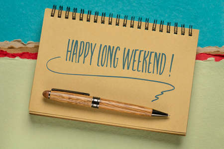 Happy long weekend  - handwriting in a spiral notebook against colorful abstract paper landscape
