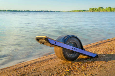One-wheeled electric skateboard (personal transporter) on a lake shore in Colorado