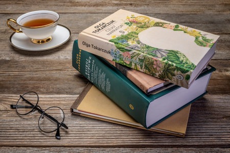 Fort Collins, CO, USA - March 8, 2020: Polish edition of several books by Olga Tokarczuk with tea and reading glasses - 2018 Nobel Prize in literature.のeditorial素材
