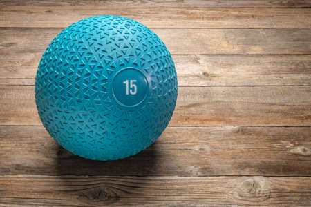 heavy rubber slam ball filled with sand on a rustic wooden deck, exercise and fitness conceptの写真素材