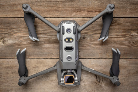 Fort Collins, CO, USA - July 2, 2021: DJI Mavic 2 pro quadcopter drone upside down on a wooden deck displaying proximity sensors, data ports and a camera with ND filter for videography.のeditorial素材