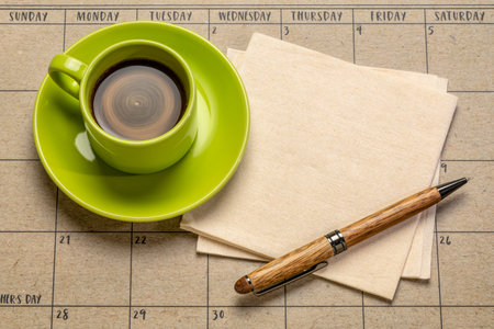 coffee, napkin and pen against desktop calendar, business still lifeの写真素材