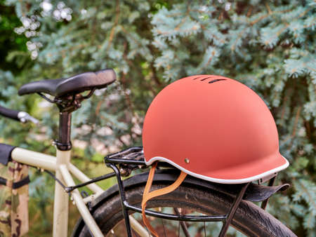 biking helmet on racks of a touring or gravel bike against forest background - safe riding,...