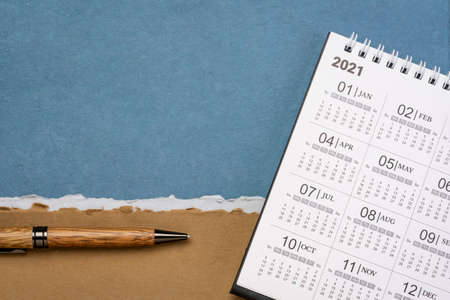 2021 spiral desktop calendar against handmade paper with a copy space, time management and business conceptの写真素材