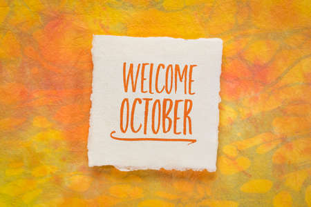 Welcome October greeting note  - handwriting on a handmade rag paper against marbled paper, calendar conceptの写真素材