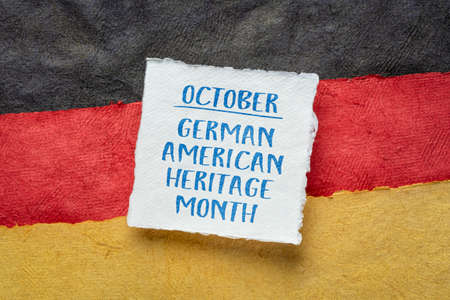 October - German American Heritage Month, square note against paper abstract in colors of Germany national flag, reminder of cultural eventの写真素材