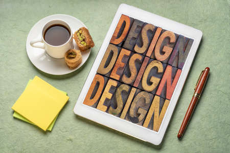 design - word abstract in vintage wood letterpress block types on a digital tablet with a cup of coffee and baklava pastryの写真素材