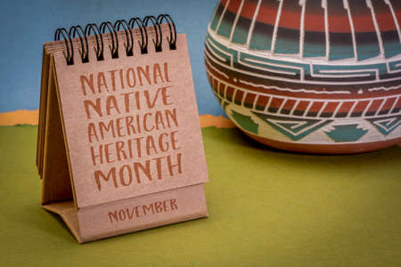 November - National Native American Heritage Month, handwriting in a desktop calendar with ceramic vase against abstract paper landscape, reminder of historical and cultural eventの写真素材