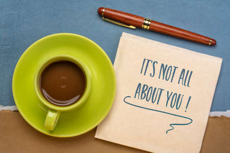It is not all about you - reminder note to self, handwriting on a napkin with a cup of coffee, relationship and personal development conceptの写真素材