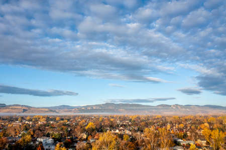 city of Fort Collins (residential area) and Front Range of Rocky Mountains in northern Colorado, aerial view in fall scenery in sunrise lightの写真素材