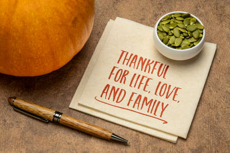 thankful for live,love, and family - Thanksgiving concept, handwriting on a napkin with a pumpkin...