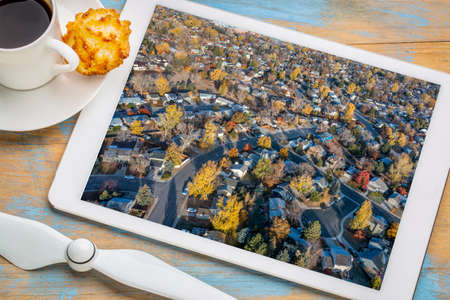 residential area of Fort Collins in northern Colorado in late fall scenery at sunrise, reviewing an aerial image on a digital tabletの写真素材