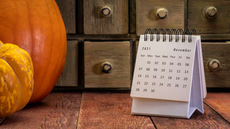 November  2021 - spiral desktop calendar on a weathered barn wood table with rustic apothecary...
