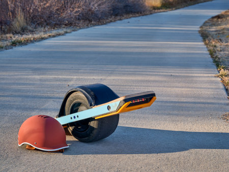 One-wheeled electric skateboard (personal transporter) with a helmet on a paved bike trail