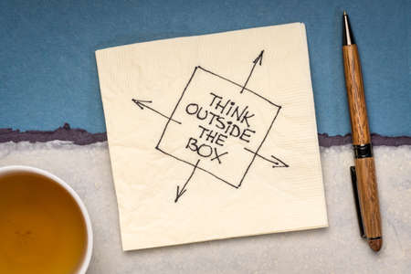 think outside the box inspirational reminder or advice - drawing on a cocktail napkin with a cup of...