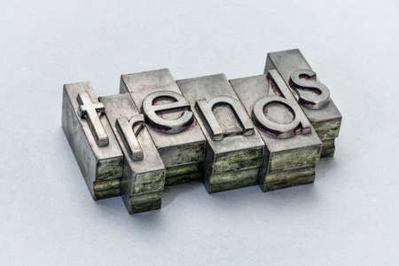 trends word abstract in grunge letterpress metal type against textured paper, business or finance conceptの写真素材