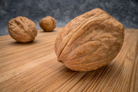 English walnuts on wooden board, low angle macro shot with probe lensの写真素材
