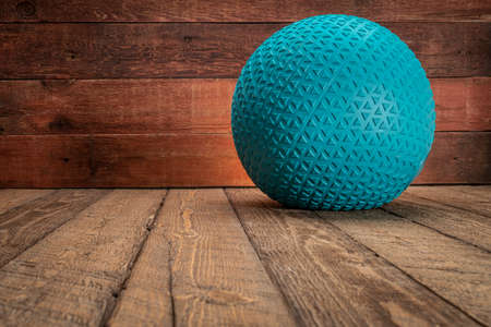 heavy rubber slam ball filled with sand on a rustic wooden backgrouind, exercise and fitness conceptの写真素材