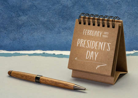 February 3rd Monday, Presidents Day, the birhtday of George Washington - handwriting in a spiral desktop calendar against abstract paper landscape, calendar conceptの写真素材