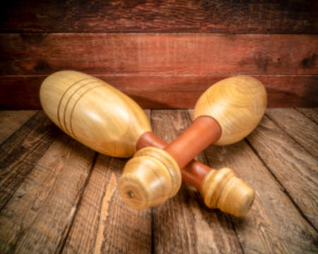 pair of wooden Indian clubs against rustic, weathered wood background - functional fitness concept, soft focus image shot with a lensless pinhole camera,の写真素材
