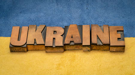 Ukraine - word in vintage letterpress wood type against blue and yellow paper background in colors of Ukrainian national flagの写真素材