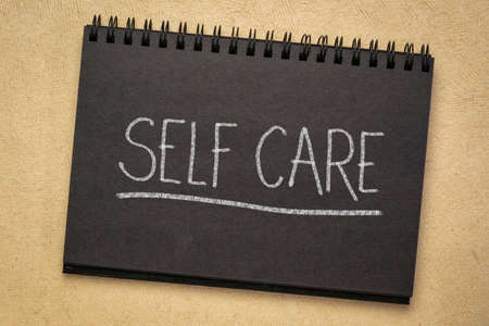 self care - white chalk writing in a black paper spiral notebookの写真素材