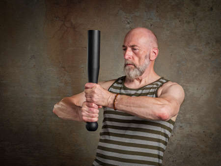 head and shoulder portrait of senior man (in late 60s) exercising with a heavy steel club,  fitness...