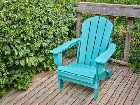 empty Adirondack chair on a wooden backyard deck, summer scenery in COloradoの写真素材