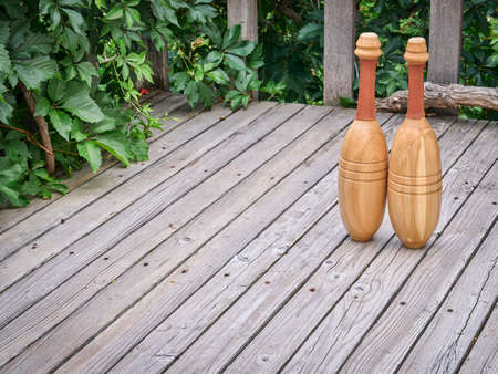 pair of Indian exercise clubs on a wooden deck - functional fitness concept, clubs are particularly...