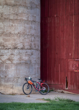lightweight gravel bike with a carbon frame against silo of old, weathered barn at Colorado foothillsの写真素材