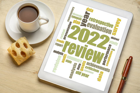 2022 year review word cloud on a digital tablet, flat lay with a cup of coffee, end of year business analysis conceptの写真素材