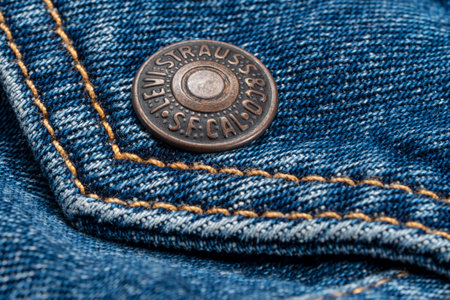 Fort Collins, CO, USA - November 7, 2022: Closeup of a metal, pocket button on Levi-Strauss trucker jacket. Levi Strauss & Co. is American clothing company known worldwide for its Levis brand of denim jeans.のeditorial素材