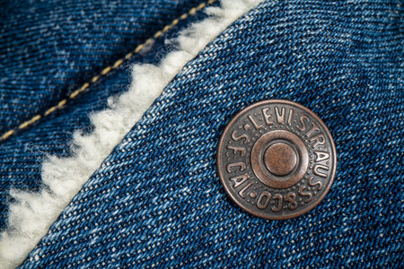 Fort Collins, CO, USA - November 14, 2022: Closeup of a metal button on Levi-Strauss trucker jacket. Levi Strauss & Co. is American clothing company known worldwide for its Levis brand of denim jeans.のeditorial素材