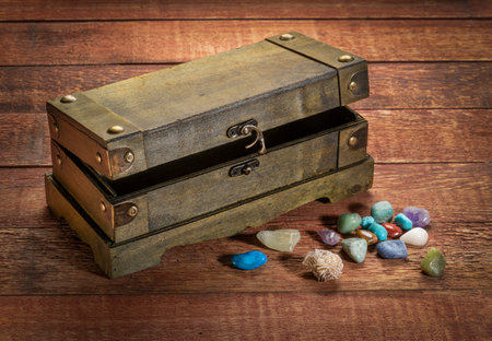 retro decorative box or treasure chest on wooden rustic table with gemstones