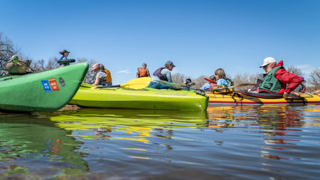 Evans, CO, USA - April 1, 2023: A group of kayakers is resting on a sandbar after dam portage during springtime paddling trip on the South Platte River.のeditorial素材