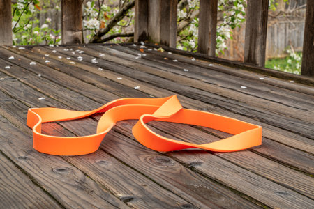 heavy duty resistance exercise band for fitness and rehabilitation on wooden backyard deck,...