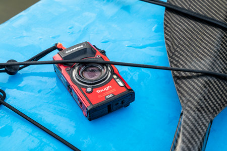 Fort Collins, CO, USA - June 6, 2023: Compact, waterproof Olympus Stylus Tough TG-5 camera on a wet deck of a stand up paddleboard.のeditorial素材