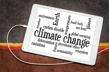 climate change word cloud on a digital tablet against abstract paper landscapeの写真素材