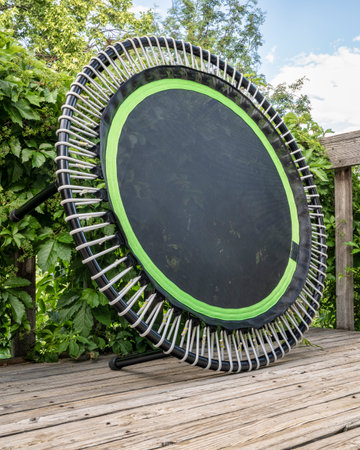 mini trampoline for fitness exercising and rebounding in a backyard patio, summer sceneryの写真素材