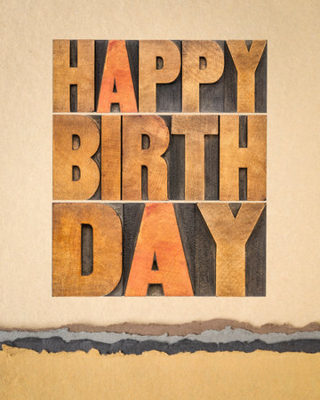 happy birthday greeting card - text in vintage letterpress wood type against art paperの写真素材