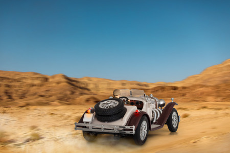 Sports car model drives through the desert sandの写真素材