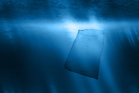 A plastic bag floats underwater in the oceanの写真素材